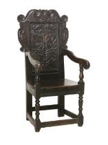 A Joined Oak Wainscot-Type Armchair, the carved top rail above a moulded back support carved with