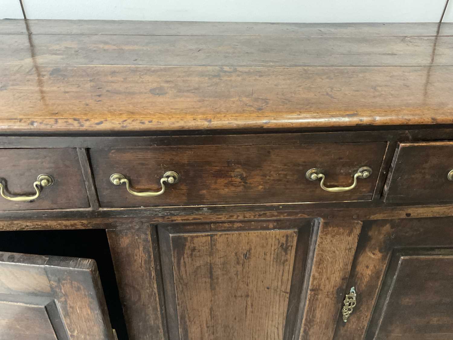 A George II Oak Enclosed Dresser Base, mid 18th century, the three plank top above three pine- - Image 8 of 9