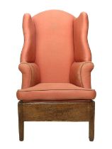 An Early 19th Century Wingback Armchair, recovered in worn pink geometric patterned fabric, the