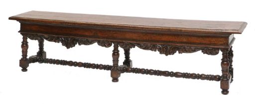 An Early 18th Century Turned Walnut Double Stool, the moulded top with moulded seat rail and