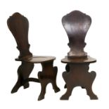 A Pair of George III Mahogany Hall Chairs, circa 1800, each of scabello form, the solid back