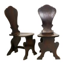 A Pair of George III Mahogany Hall Chairs, circa 1800, each of scabello form, the solid back