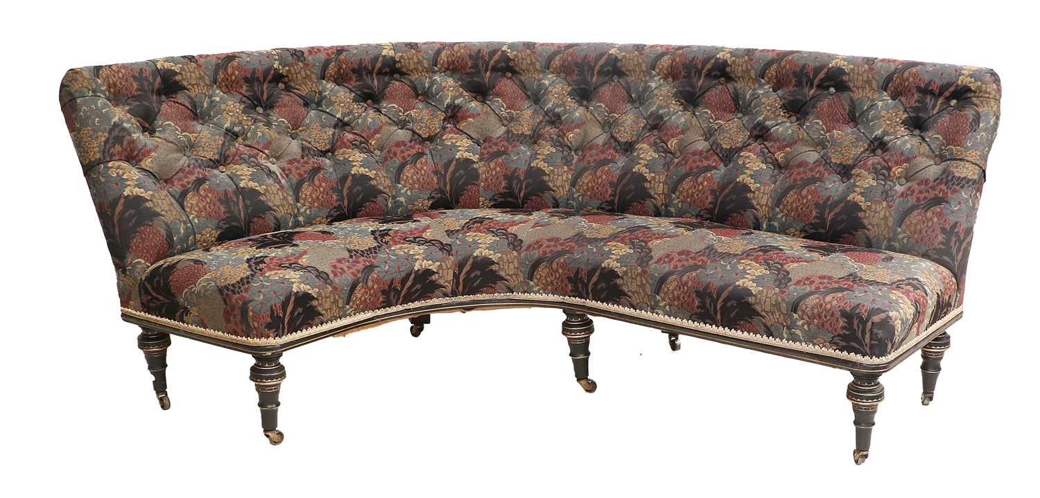 A Victorian Ebonised and Parcel-Gilt Curved Sofa, late 19th century, recovered in blue and red