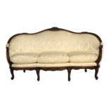 A Late 19th Century Carved Walnut or Beech Three-Seater Sofa, covered in yellow silk damask, the