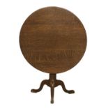 A George III Oak Circular Tripod Table, late 18th century, the flip-top on a vasiform support with