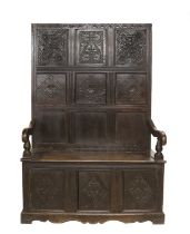 A Carved Oak Settle, the associated back support with nine panels carved with lozenges and scrolls