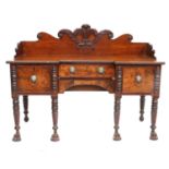 An Irish Regency Carved Mahogany Sideboard, early 19th century, with three-quarter scrolled and