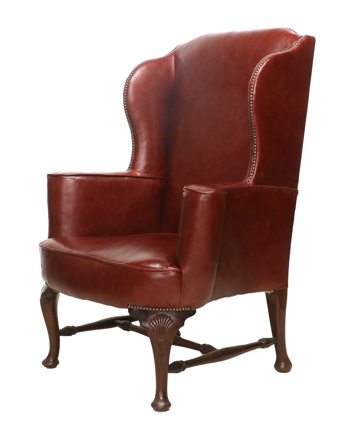 A George III-Style Wing-Back Library Armchair, recovered in close-nailed red leather, with