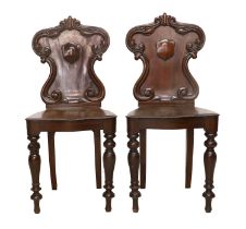A Pair of Victorian Mahogany Hall Chairs, mid 19th century, the scrolled and carved back supports