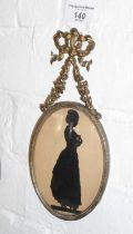 19th c. silhouette of a lady in oval brass frame with floral swag