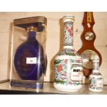 Dimple ceramic decanter of whisky, a 100th Anniversary decanter of Metaxa and a smaller similar