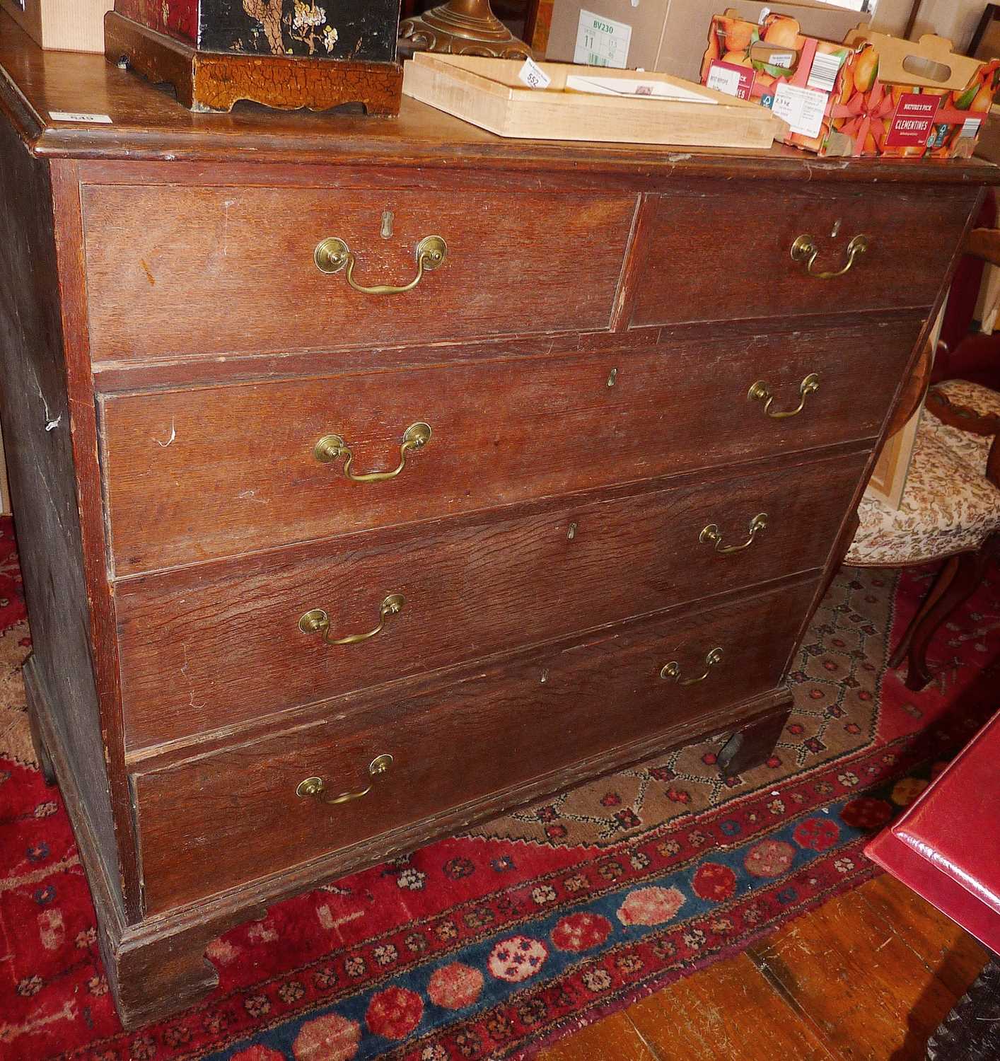 Georgian oak chest of five drawers (2 over 3) with brass swan neck handles standing on bracket feet,