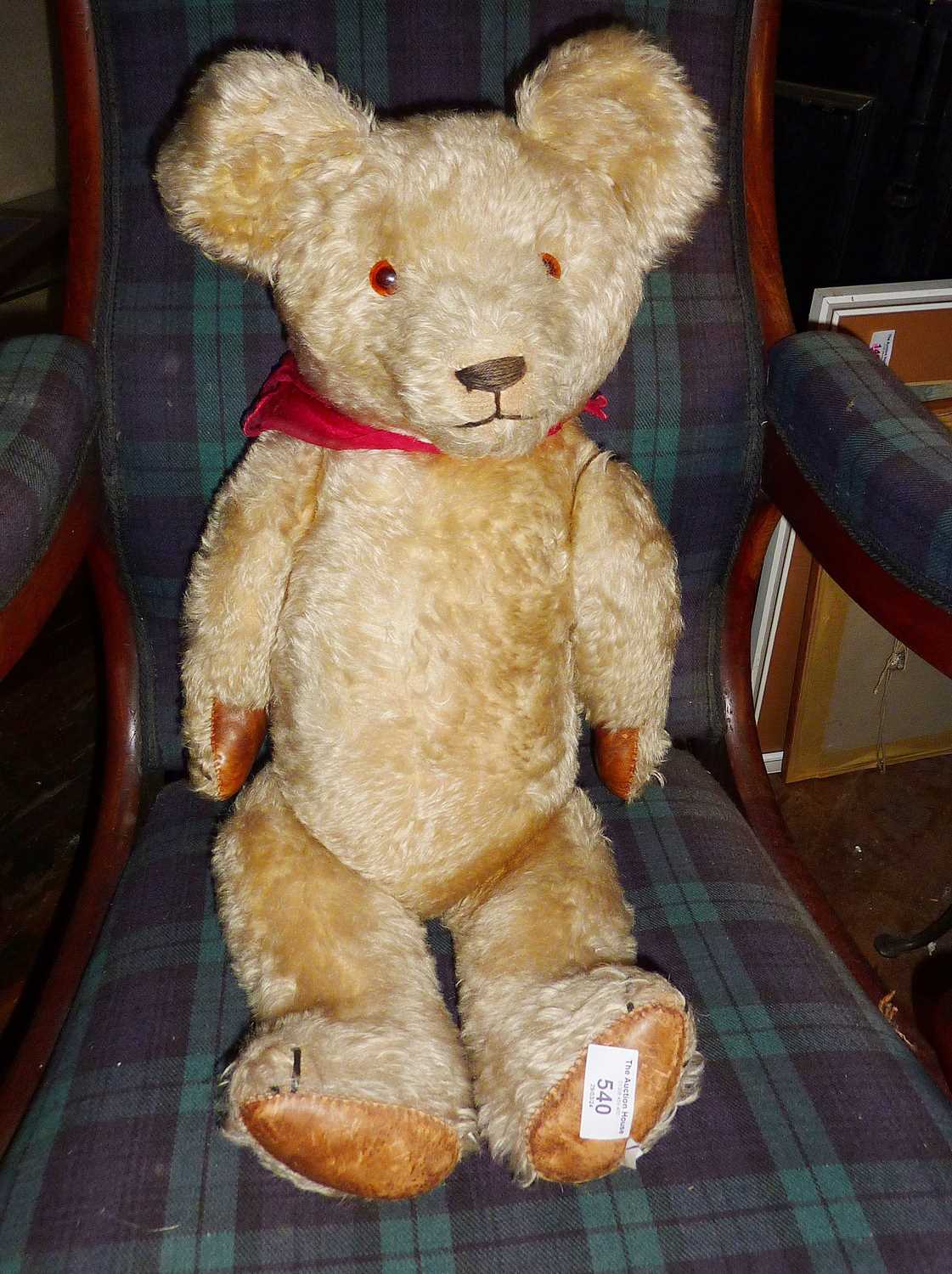 Large vintage teddy bear, fully jointed, with hump back, amber glass eyes and leather pads.