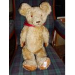 Large vintage teddy bear, fully jointed, with hump back, amber glass eyes and leather pads.