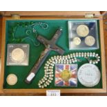 Coins, jewellery and a crucifix in a glazed tabletop display case