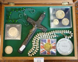 Coins, jewellery and a crucifix in a glazed tabletop display case