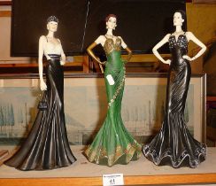 Three resin figures of women in evening dress, 34cm high