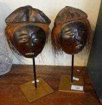 Tribal Art: Pair of Andaman Island carved coconut heads with bone teeth and resting on metal stands