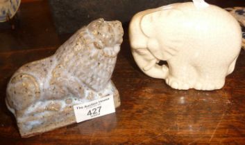 Small glazed stoneware figure of a lion by A.H. Gerrard of Millbank Pottery and a crackle white