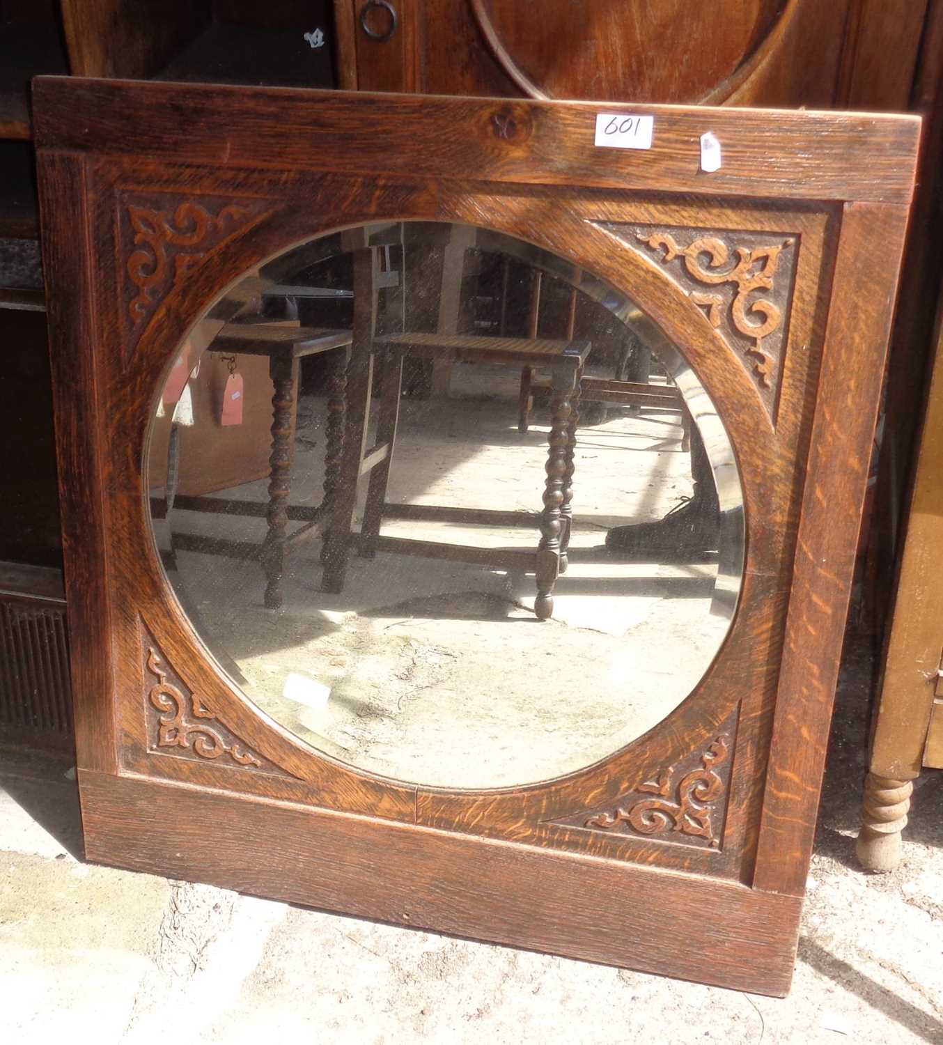 Round mirror with bevelled edge in carved oak frame