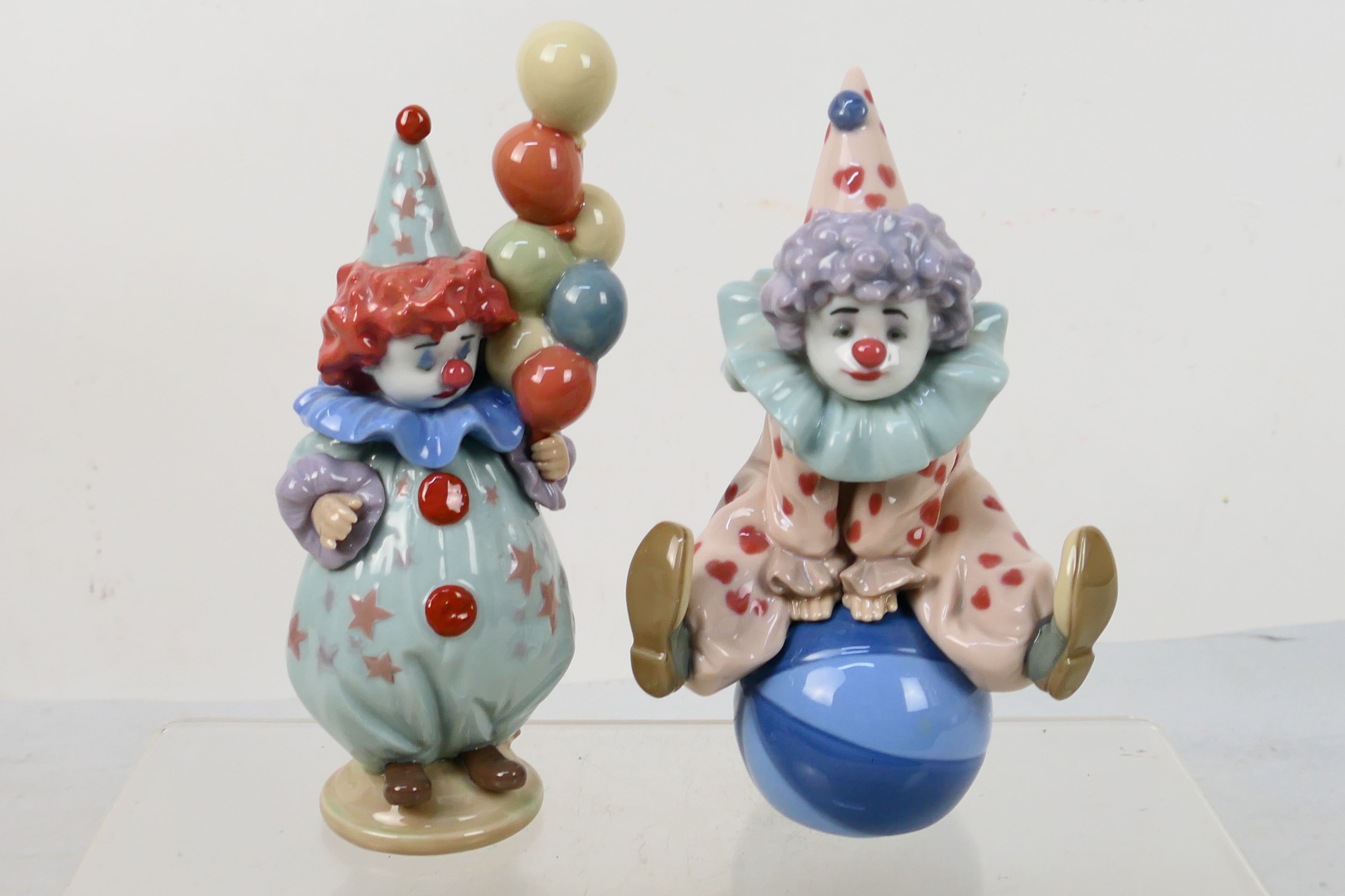 Two Lladro figures depicting young clowns comprising # 5813 Having A Ball and # 5811 Littlest Clown,
