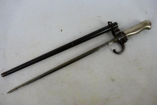 A French model 1886 bayonet with 34 cm (l) cruciform blade, with scabbard.