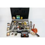 An aluminium case containing mixed collectables to include watches, sunglasses, belt buckles,