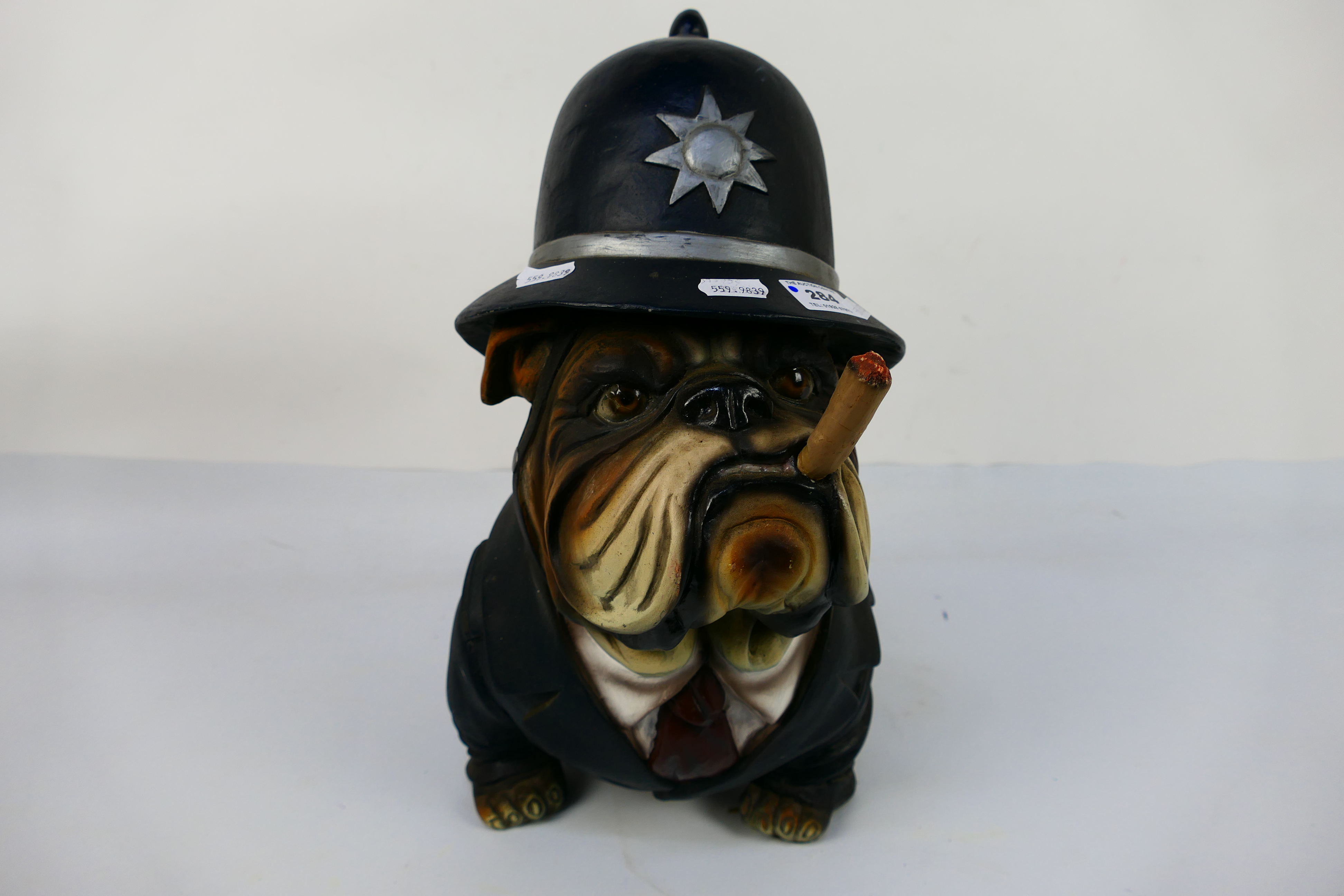 A model depicting an English Bulldog in police uniform smoking a cigar, approximately 39 cm (h).