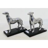 A pair of white metal, Art Deco style dog figures on black bases, approximately 20 cm (h). [2].