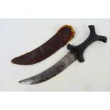 An African Hadendoa tribal knife with curved 19 cm (l) blade, X form hilt and leather sheath.