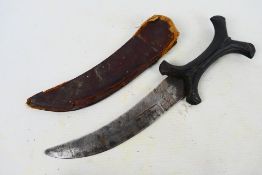 An African Hadendoa tribal knife with curved 19 cm (l) blade, X form hilt and leather sheath.