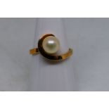 A lady's yellow metal ring stamped 10KT, JR with single synthetic pearl stone, size M, approx 2.