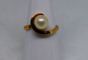 A lady's yellow metal ring stamped 10KT, JR with single synthetic pearl stone, size M, approx 2.