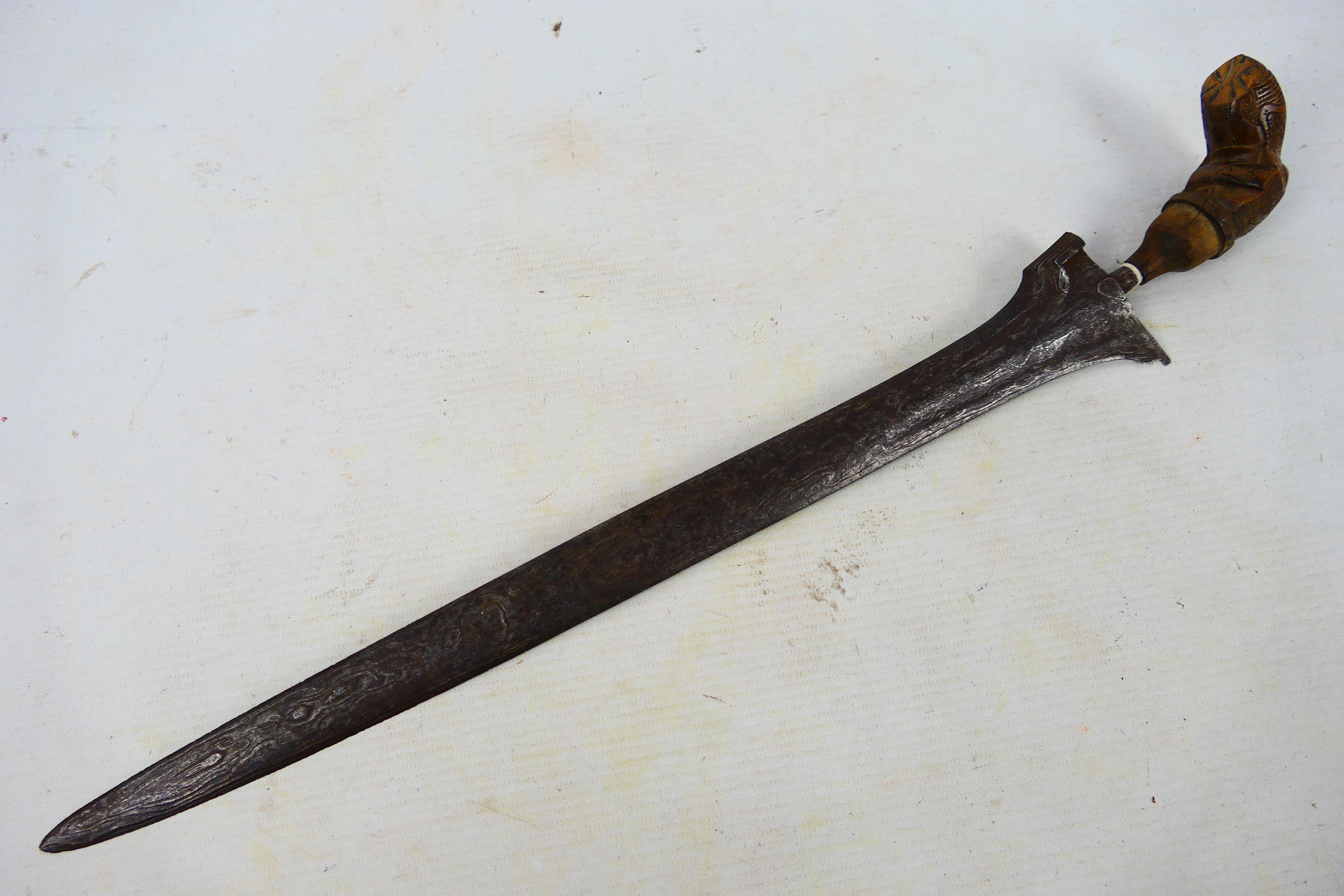A late 19th or early 20th century Indonesian kris, 39 cm (l) blade and shaped carved hilt.