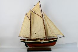 A model boat mounted to wooden display p