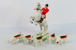 Beswick hunting figures comprising huntsman on rearing white horse # 868 and five fox hounds,