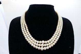 A lady's three-strand seed pearl necklace with 9 ct sapphire and seed pearl set clasp,