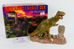 A boxed TeleMania novelty telephone in the form of a Tyrannosaurus Rex.