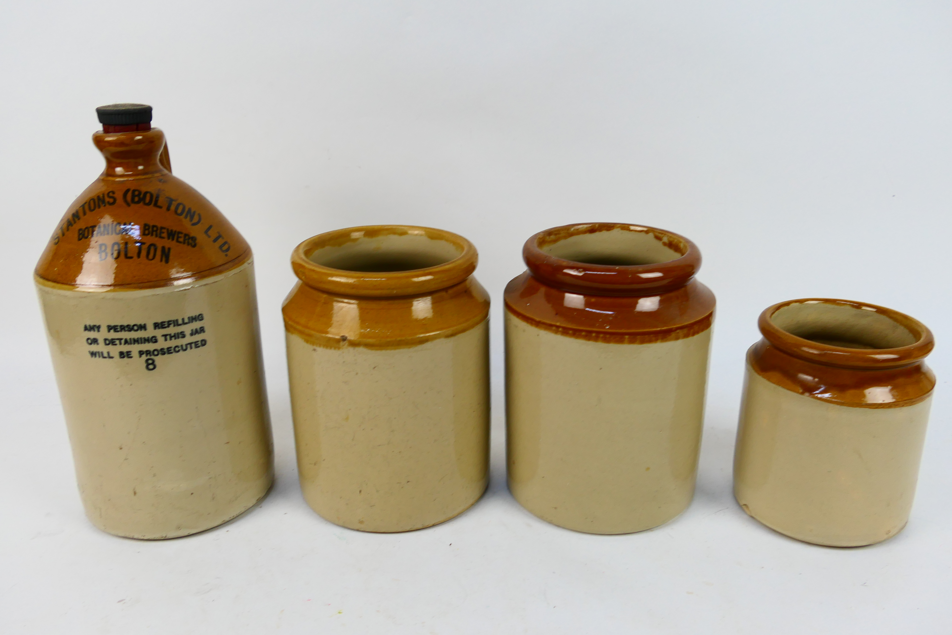 Three stoneware jars and a Stantons (Bolton) Ltd Botanical Brewers flagon.
