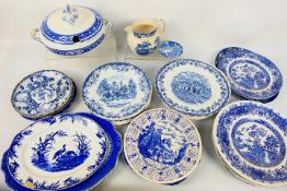 A collection of blue and white ceramics, predominantly plates.