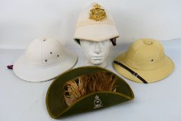 Three pith helmets, one with 24th Regime