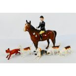 A Beswick huntswoman figure, 21 cm (h), four fox hounds and a fox figure.