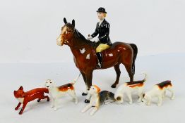 A Beswick huntswoman figure, 21 cm (h), four fox hounds and a fox figure.