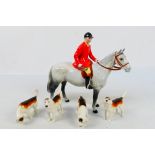 A Beswick huntsman on grey horse, 21 cm (h) and four fox hound figures.