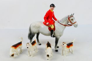 A Beswick huntsman on grey horse, 21 cm (h) and four fox hound figures.