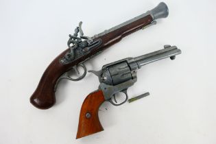 A replica Colt 45 Peacemaker 1873 revolver and a replica flintlock pistol.