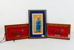 Two framed cap badge and bullet displays