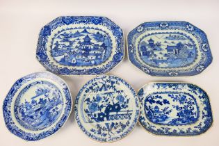 A collection of Chinese blue and white dishes, predominantly decorated with landscape scenes,