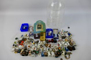 A quantity of ceramic and metal thimbles with a plastic thimble stand. Contains some silver content.