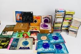A collection of vintage audio cassettes and 7" vinyl records. [3].